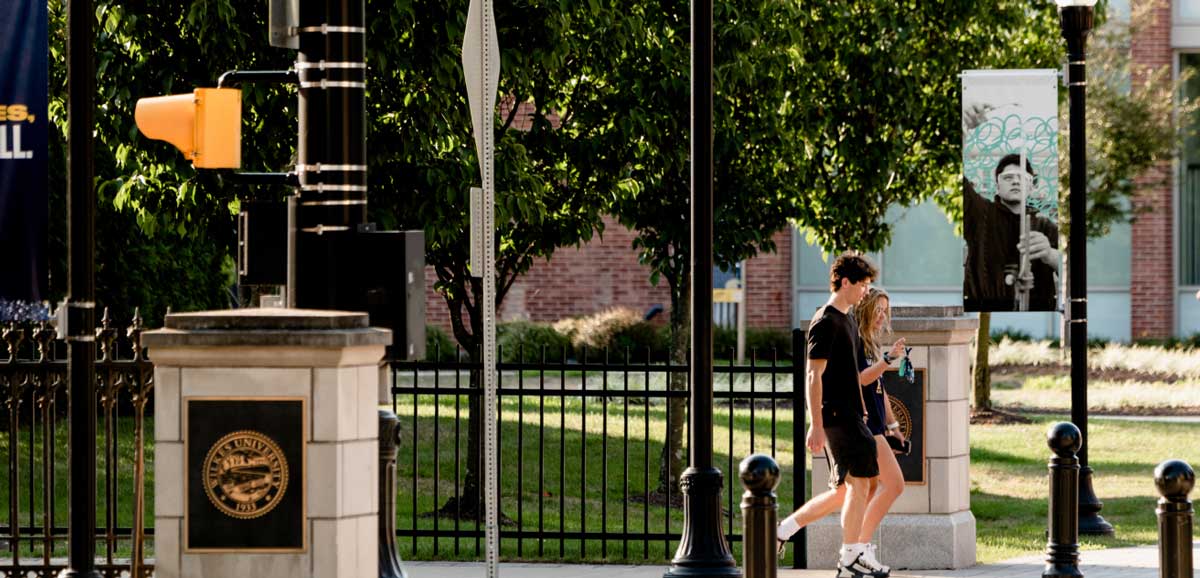 two students walking on sidewalk