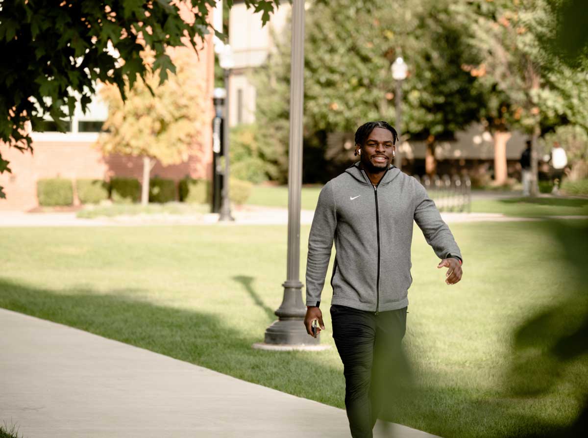 happy young man walking on campus